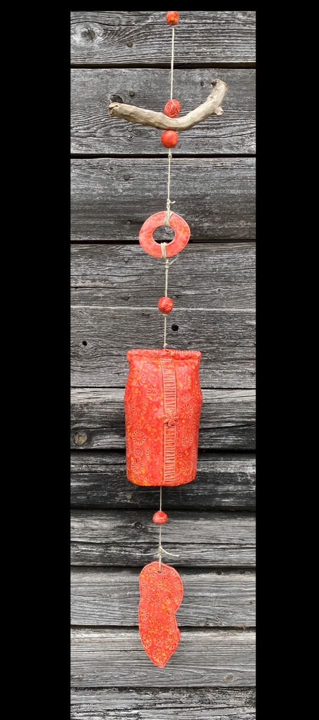 Orange ceramic bell against weathered wood